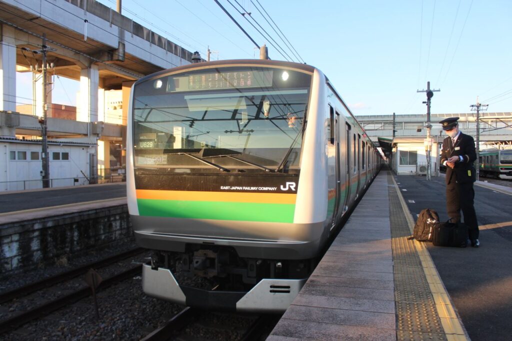 Train at Oyama Station with a conductor, capturing urban life in Japan.