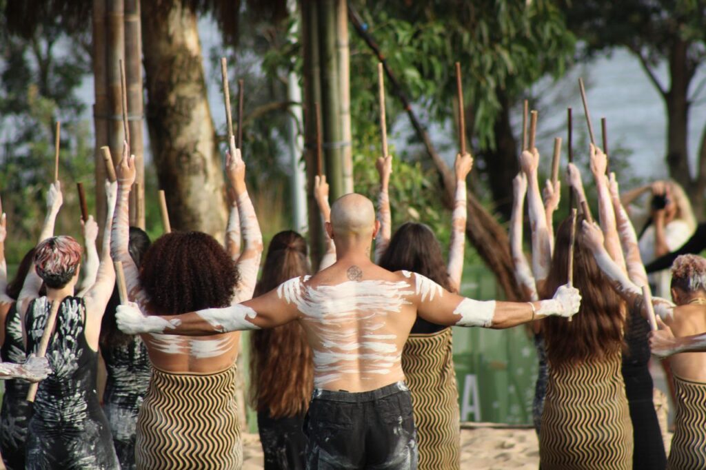 Group of dancers in traditional Aboriginal attire performing outdoors.